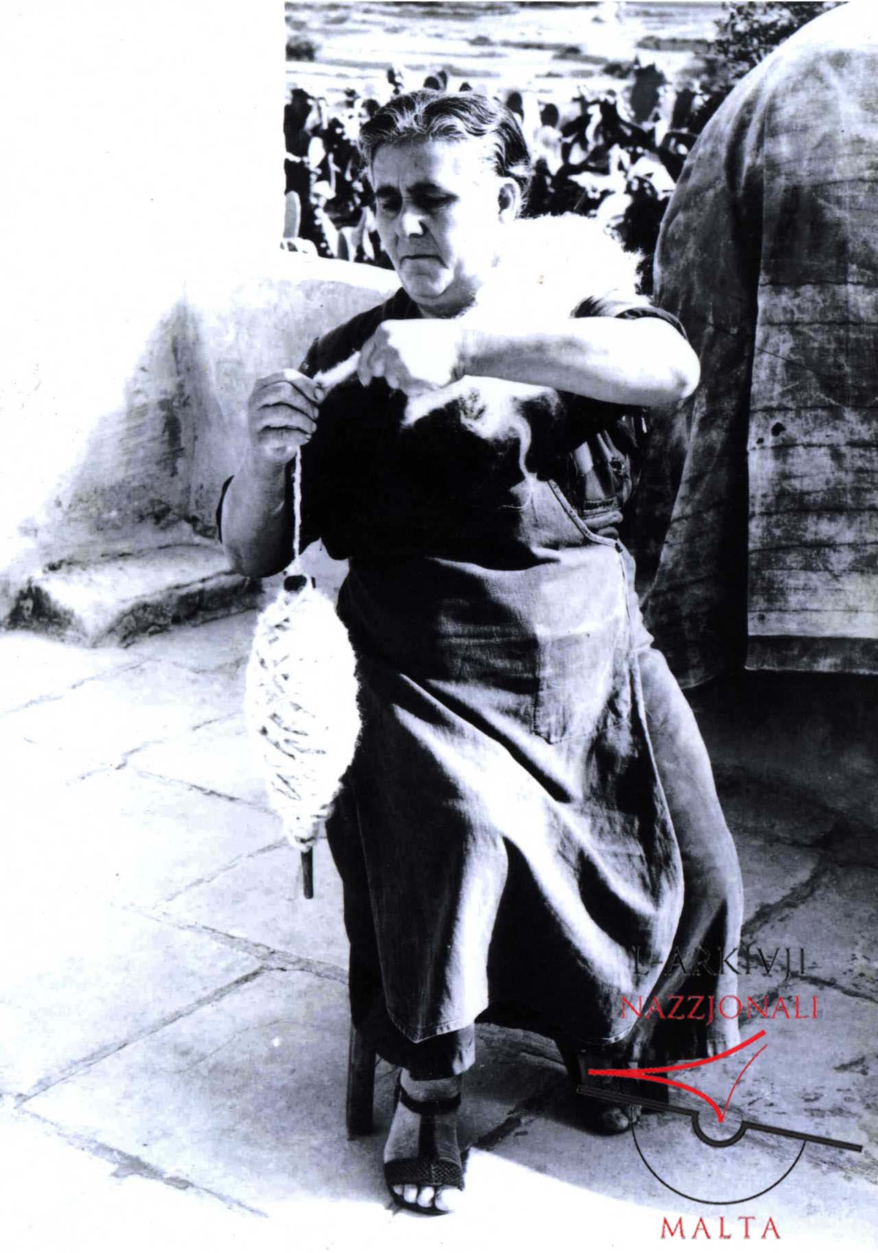 Woman making thread from wool